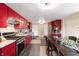 Stylish kitchen with red cabinetry, stainless steel appliances, granite countertops, and eat-in table at 4601 N Legacy Dr, Muncie, IN 47304