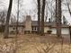 Ranch style home features a stone chimney and two-car garage nestled among mature trees at 4621 E 37Th St, Indianapolis, IN 46218