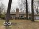 Charming single-story home featuring a stone chimney and mature trees in a peaceful residential setting at 4621 E 37Th St, Indianapolis, IN 46218