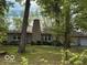 Charming one-story home featuring a stone chimney and a well-maintained front lawn with mature trees at 4621 E 37Th St, Indianapolis, IN 46218