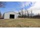The white metal-sided shop offers a functional space with a large access door and lean-to at 5682 N Michigan Rd, Fairland, IN 46126