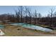 Aerial view of a frozen pond surrounded by trees, with a fire pit on the grassy bank at 5682 N Michigan Rd, Fairland, IN 46126