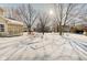 Snowy backyard with mature trees and a view of neighboring homes at 7891 Tufton Ct, Fishers, IN 46038