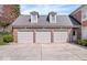 Spacious three-car garage with neutral doors complementing the brick facade and gabled dormers at 10901 Brigantine Dr, Indianapolis, IN 46256