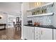 Stylish wet bar with white shaker cabinets, herringbone tile, and quartz countertop at 10901 Brigantine Dr, Indianapolis, IN 46256