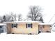 Tan brick ranch house with snow covered yard at 1314 Chester St, Anderson, IN 46012