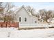 Gray sided house with red and white picket fences and snowy yard at 1430 St Paul St, Indianapolis, IN 46203