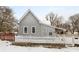 Gray sided house with white picket fence and snowy yard at 1430 St Paul St, Indianapolis, IN 46203