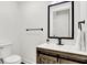Small bathroom with wood vanity and black framed mirror at 1745 S Talbott St, Indianapolis, IN 46225