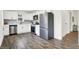 Modern white kitchen with stainless steel appliances and wood-look flooring at 1745 S Talbott St, Indianapolis, IN 46225