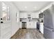 Bright kitchen featuring white cabinets, stainless steel appliances, and wood flooring at 1745 S Talbott St, Indianapolis, IN 46225