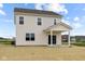 The home's back exterior features a covered patio, sliding glass doors, and a spacious yard with a seeding of grass at 1845 James Pierce Dr, Shelbyville, IN 46176