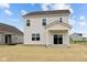 Rear view of a home with a covered porch, sliding glass doors, windows, and a spacious newly seeded yard at 1845 James Pierce Dr, Shelbyville, IN 46176