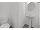 Modern bathroom featuring a pedestal sink, toilet, and light hardwood flooring at 1845 James Pierce Dr, Shelbyville, IN 46176