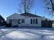 Ranch home with snow-covered yard, fenced-in area, and visible address number at 2301 S Vine St, Muncie, IN 47302