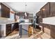 Modern kitchen featuring dark brown cabinets, granite countertops, and a kitchen island at 2449 Lingerman Way, Avon, IN 46123