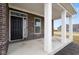 Inviting front porch with brick accents, white columns, and a stylish black front door at 4201 Risen Star Way, Bargersville, IN 46106