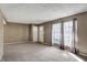 Spacious living room features carpeted floors, three windows, and neutral wall colors at 4814 Oakwood Trl, Indianapolis, IN 46268