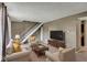 Bright living room features carpeted floors, seating, white stairs, and a modern entertainment center at 4814 Oakwood Trl, Indianapolis, IN 46268