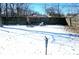 Backyard with an open snow-covered space and a dark wood fence in the background at 4818 E 14Th St, Indianapolis, IN 46201