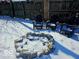 Backyard fire pit and patio chairs covered in snow in this backyard setting at 4818 E 14Th St, Indianapolis, IN 46201