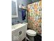 Bathroom with floral shower curtain, white sink, and gray wooden paneling at 4818 E 14Th St, Indianapolis, IN 46201