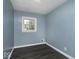 Cozy bedroom with light blue walls, wood floors, and a window for natural light at 4818 E 14Th St, Indianapolis, IN 46201