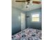 View of the bedroom with light blue walls, ceiling fan, and a window at 4818 E 14Th St, Indianapolis, IN 46201