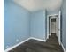 Well-lit bedroom with wood floors and light blue walls, leads to the bathroom at 4818 E 14Th St, Indianapolis, IN 46201