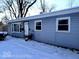 Side view of a single-story home, showcasing blue siding, windows and snow covered yard at 4818 E 14Th St, Indianapolis, IN 46201