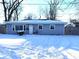 Charming single-story home with snow-covered yard and blue siding at 4818 E 14Th St, Indianapolis, IN 46201