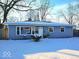 Charming single-story home with snow-covered yard and blue siding at 4818 E 14Th St, Indianapolis, IN 46201
