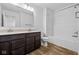 Bathroom features a double sink vanity, shower-tub combination, and attractive vinyl flooring, combining style and functionality at 5123 Rolling Meadow Blvd, Indianapolis, IN 46237