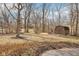 Backyard view of a storage shed with tree coverage and landscaping at 7830 Ridgeland Dr, Indianapolis, IN 46250