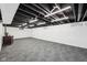 Spacious basement with painted brick, finished floor, and exposed ceiling at 7830 Ridgeland Dr, Indianapolis, IN 46250