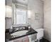 Elegant bathroom featuring sleek black countertop, modern fixtures, and stylish textured walls at 7830 Ridgeland Dr, Indianapolis, IN 46250