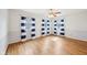 Inviting bedroom featuring hardwood floors, three large windows with decorative curtains, and a ceiling fan at 7830 Ridgeland Dr, Indianapolis, IN 46250