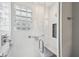 Elegant shower with textured white tile, glass block window, built-in seat, and sleek chrome fixtures at 7830 Ridgeland Dr, Indianapolis, IN 46250