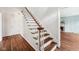 Traditional staircase with hardwood steps, white risers, and a wooden handrail, leading to an upstairs area at 7830 Ridgeland Dr, Indianapolis, IN 46250