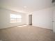 Light filled bedroom featuring plush carpeting, neutral walls, and a window and open doorway at 801 Blaine Dr, Whiteland, IN 46184