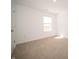 A bright bedroom with neutral carpet, white walls, and natural light from the window at 801 Blaine Dr, Whiteland, IN 46184