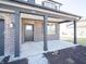 Inviting covered front porch featuring brick accents, dark pillars, and a view of the home's entrance at 801 Blaine Dr, Whiteland, IN 46184