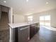 Contemporary kitchen with island, stainless steel dishwasher, and hardwood floors, next to stairwell at 801 Blaine Dr, Whiteland, IN 46184