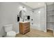 Updated bathroom with walk-in shower, wood vanity, and neutral tile at 8810 Beechwood Ave, Indianapolis, IN 46219