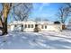 Newly renovated white house with a snow covered front yard at 8810 Beechwood Ave, Indianapolis, IN 46219
