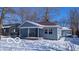 Cute bungalow with front porch, snow-covered yard, and single-car garage at 1313 S Riley Ave, Indianapolis, IN 46203