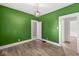 Green dining room with hardwood floors and window at 1921 E Pleasant Run Pkwy S S Dr, Indianapolis, IN 46203