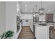 Modern kitchen with white cabinets, stainless steel appliances, and large island at 19381 Sumrall Pl, Westfield, IN 46074
