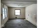 An empty bedroom undergoing renovation, featuring hardwood floors and a window at 2729 Columbia Ave, Indianapolis, IN 46205