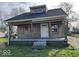 Charming stone cottage with a covered front porch, steps, and a newly installed roof at 2729 Columbia Ave, Indianapolis, IN 46205